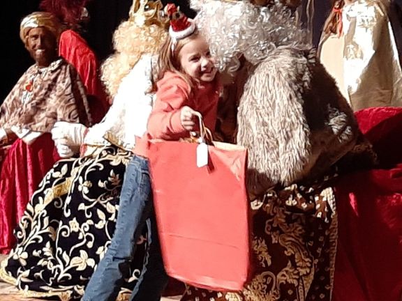 Una alumna recibe ilusionada su regalo de parte de un rey Mago