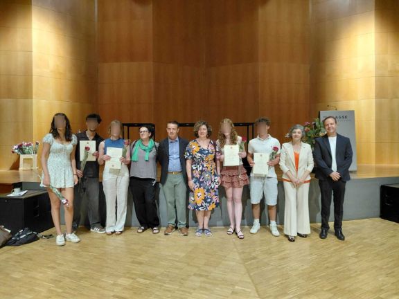 Fila de alumnado y profesores posando en un auditorio