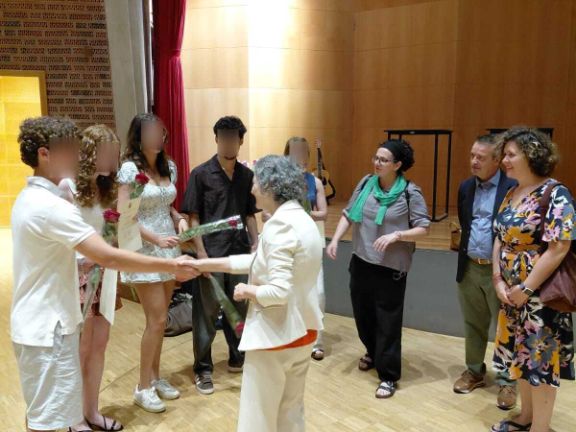 Embajadora de España saludando a un grupo de alumnado en un auditorio