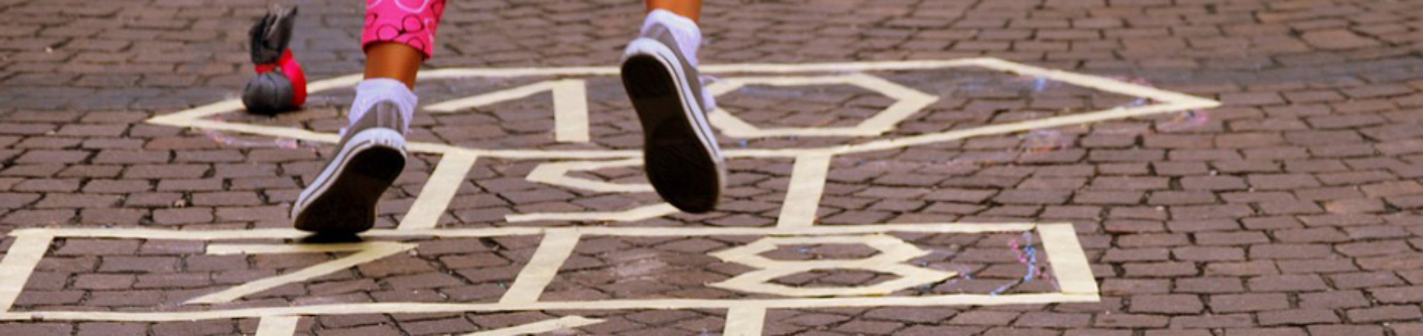 Imagen de una niña saltando a la rayuela