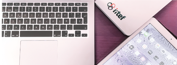 Fotografía del teclado de un ordenador portátil, una tableta y una libreta.