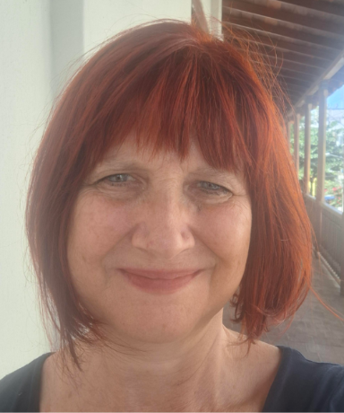 fotografía en color y primer plano de Sonia Bailini. Mujer de unos cinquenta años, ojos azules, pelo corto y rojizo. Rostro sonriente y afable